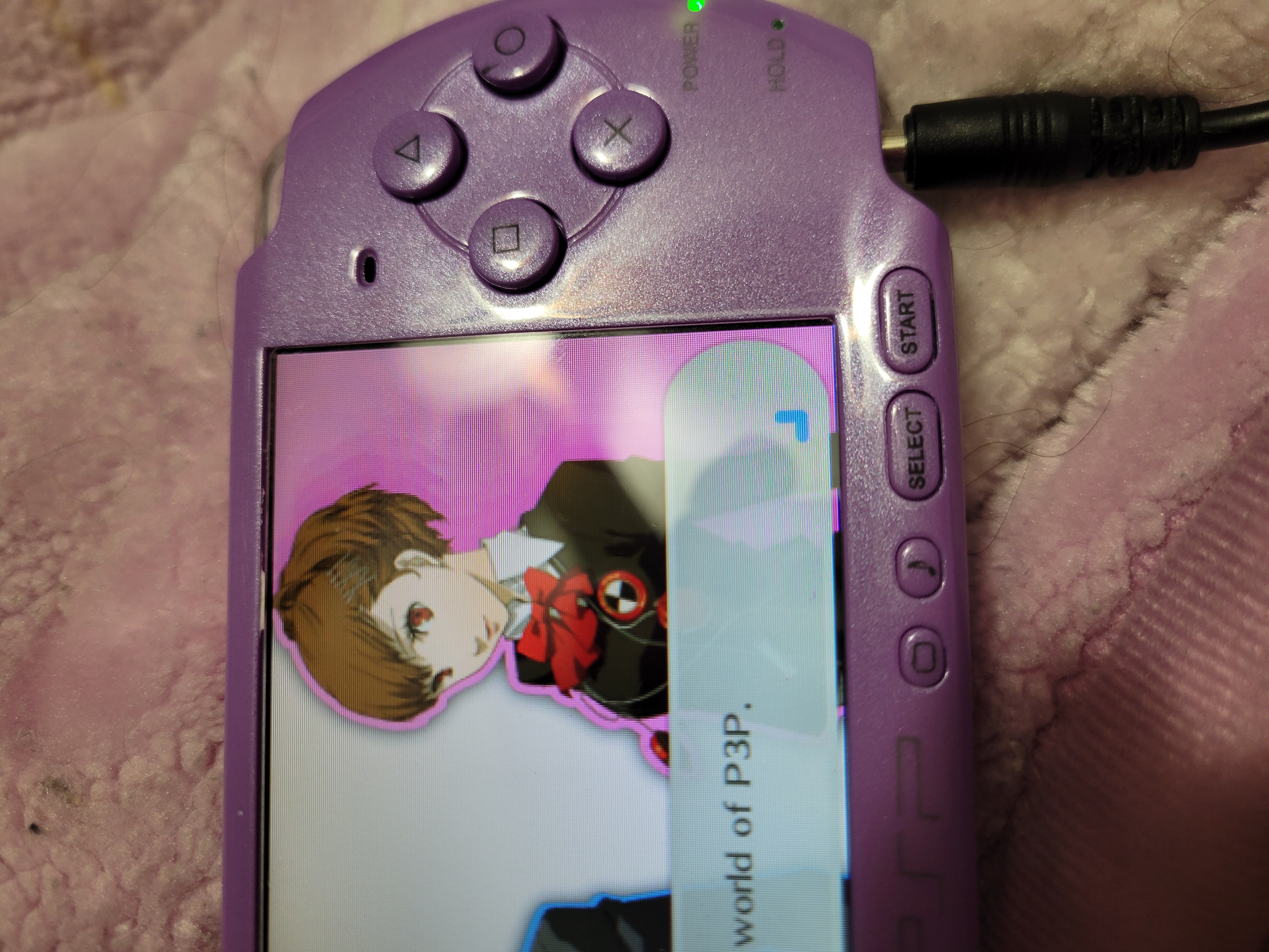 Purple Playstation Portable that has the protagonist selection from Persona 3 portable on the screen.